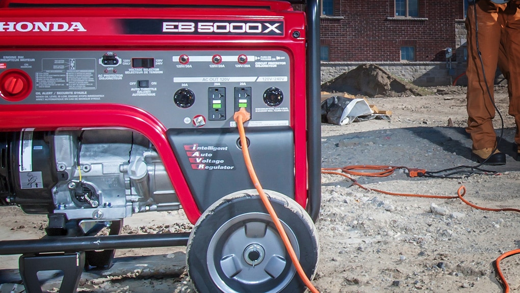 Close up of generator on worksite with man and brown house in background